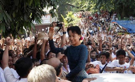 Aung San Suu Kyi waves to supporters gathered to hear her speech outside the headquarters of her National League for Democracy party in Yangon